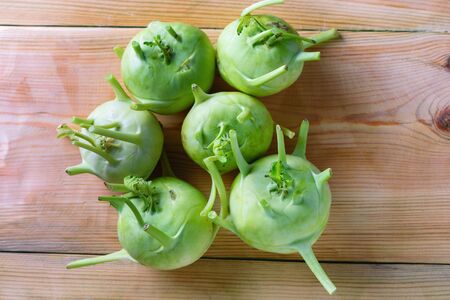 Fresh green kohlrabi on wood background.Kohlrabi or German turnip or turnip cabbage is a biennial vegetable, and is a low, stout cultivar of cabbage.の写真素材