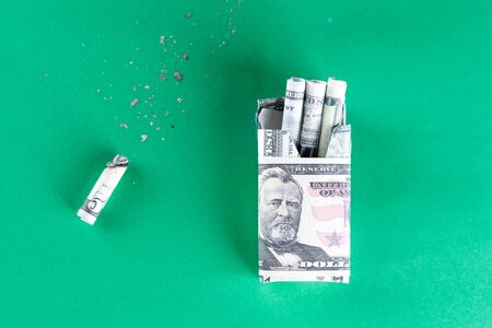 Package of cigarette filled with paper money dollars banknote and Cigarette butt. Smoking is bad for your health, actually burning or wasting money.World No Tobacco Day. Top view.の写真素材