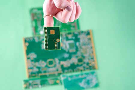 Small Electronics Circuit Boards on Human Woman Finger. Female Technician Inspecting Defective Circuit Board.の写真素材