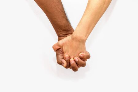 Close up shot of an mature couple holding hands. Black man and white woman in tender situation...