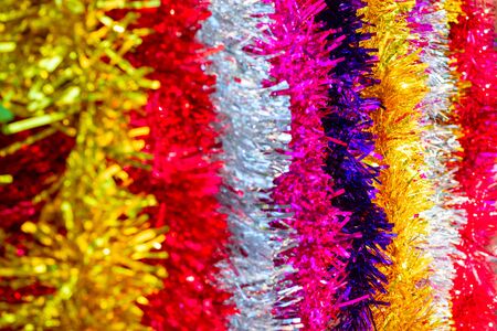Colorful Sukkot or Sukkos or Christmas tinsel. Festive background. New years fluffy gold, purple,...