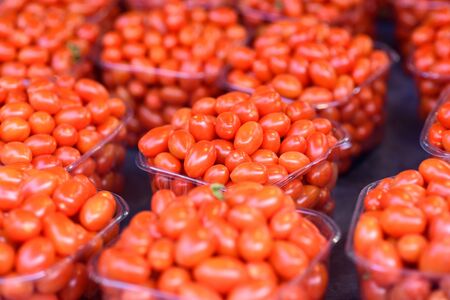 Red cherry tomato harvest. Many little tomatoes. Colorful food textures.の写真素材