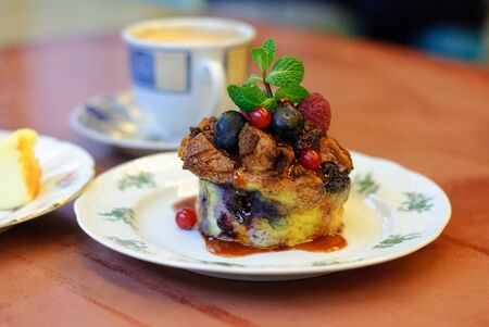 A beautiful, fresh cupcake with berries, decorated with mint leaves served in magnificent crockery...