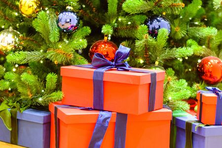 Beautiful decorated christmas tree with red and blue present boxes .