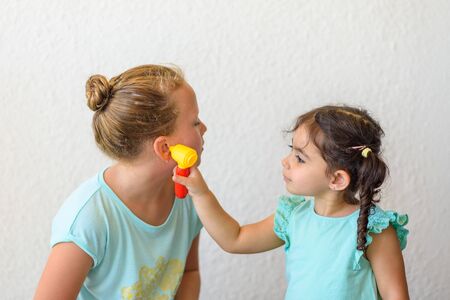 Children playing doctor. Little doctor examining patients ear.