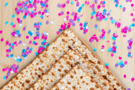 Matzah and confetti happy colorful background for Jewish Passover holiday. Pesach celebration concept.の写真素材