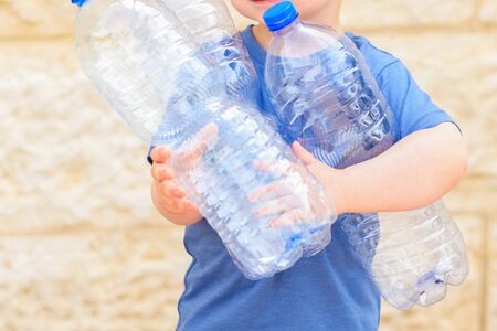Little child recycling plastic water bottles. Kid taking out the segregated garbage. Concept plastic free, zero waste. World Environment Day.の写真素材