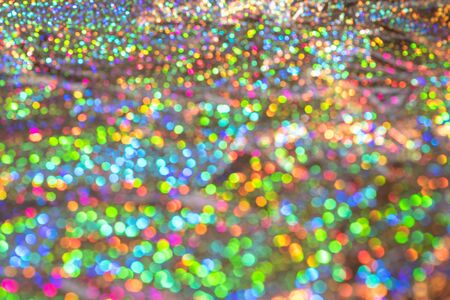 Abstract blurred of silver glittering shine bulbs lights background. Sparkle silver colorful glittering background. Real defocused lights.の写真素材