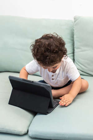 Close up of a little boy using digital tablet. Homeschool, distance learning, video call at home....