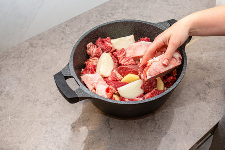 Woman Hands Prepare Beef On Kitchen. Close-up Of Cooking Traditional Jewish Cholent Hamin Main Dish...