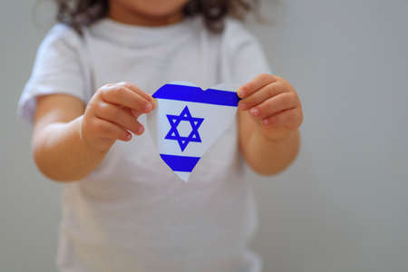 Child hands hold flag of Israel, heart shape. Love Israel concept.の写真素材