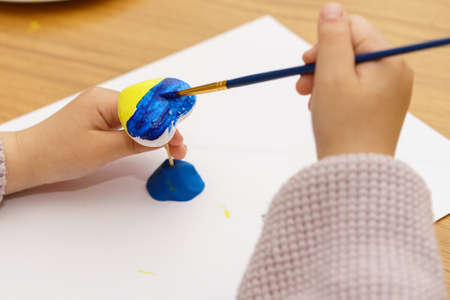 The kid draw national flag of Ukraine painted yellow and blue on heart shape. The concept of patriotism, respect, support, help and solidarity with the citizens of Ukraine.の写真素材