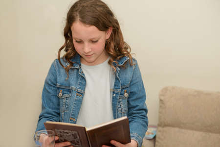Beautiful Jewish Caucasian Girl Reads Passover Haggadah During Passover Seder In Home. Jewish Family...