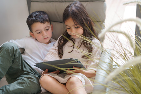 Young Children Watching Videos On Tablet At Home.の写真素材
