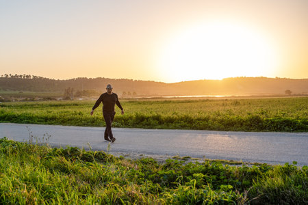Senior athlete man walking on the sunset background.の写真素材