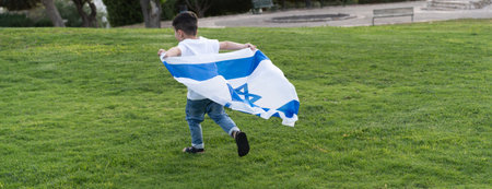 Young child running with Israeli flag. Rear view little boy running with Israel flag.の写真素材