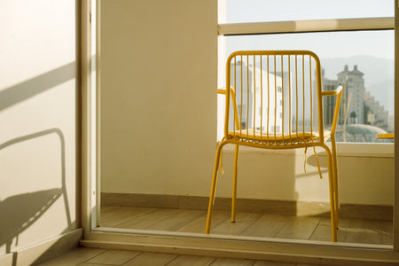 Yellow Metal Chair on Balcony with Serene View, Embracing Summer Bliss. Modern Beach House.の写真素材
