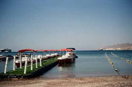 Seaside Boat Rentals In Eilat Israel, May 12, 2023. Analog film shot of boats lined up for rent on...