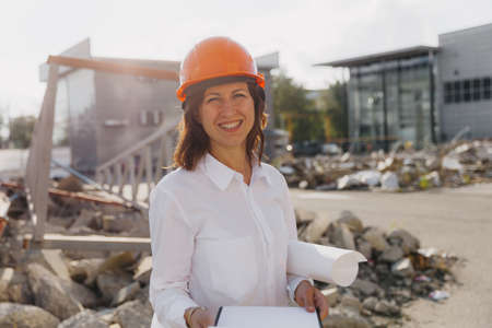 Young beautiful woman architect in white shirt and hard hat holding a flip board. woman in hard hat...