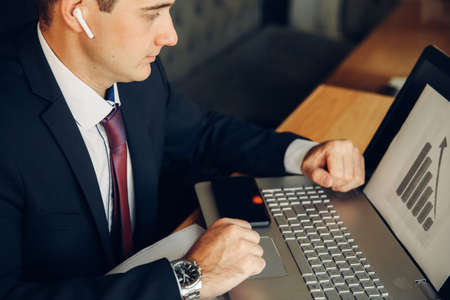male businessman using laptop in cafe. Notebook and coffee cup close up.の写真素材