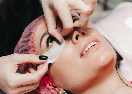 eyelash extension procedure. Female eye with long eyelashes. Close up, selective focus.
