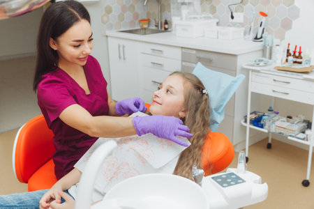 the dentist puts a dental napkin on the patient. Preparing the patient for a dental examinationの写真素材