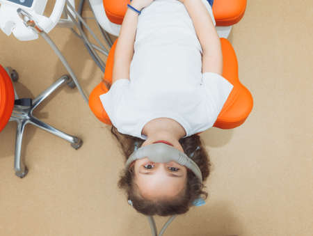 little girl with sedation mask. Treatment of children's teeth with nitrous oxide. children's dentistry.の写真素材
