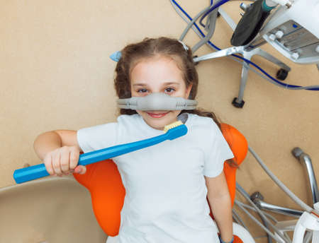 little girl with sedation mask. Treatment of children's teeth with nitrous oxide. children's...