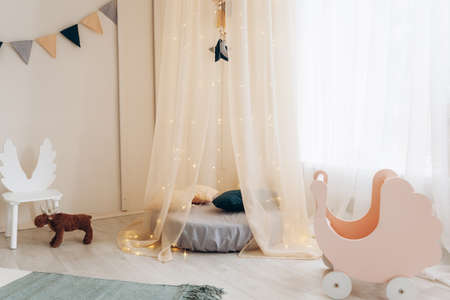 Natural, bright interior of a children's bedroom with wooden furniture, designer accessories and a tepee.の写真素材