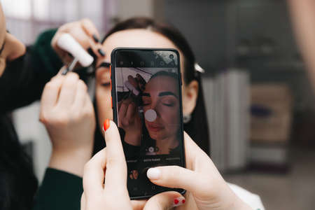 A young woman undergoes an eyebrow correction procedure in a beauty salon, close-up. the girl paints her eyebrows in the salon.の写真素材