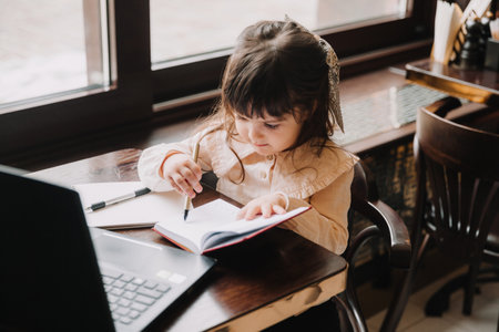 child online. A little girl uses video chat on a laptop to communicate and study.child with a laptopの写真素材