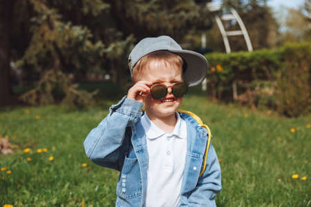 trendy boy in sunglasses in spring parkの写真素材