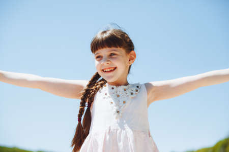 happy child on the beach.little blonde girl runs along the sand on the beach.の写真素材
