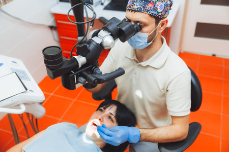 The dentist examines the patient's mouth with a dental microscope. dental treatment. the concept of healthy teeth. microscope in dentistry.の写真素材
