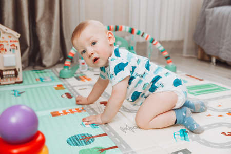 Above angle shot of adorable Baby boy lying on child friendly floor puzzle mats looking upの写真素材