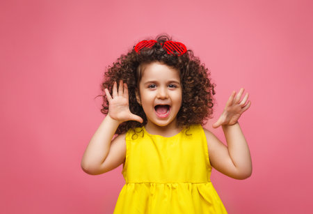 portrait of a girl in a yellow dress cute attractive cute cheerful cheerful little girl .isolated pink background.の写真素材