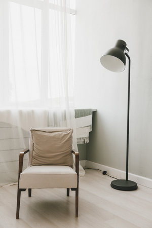 Armchair, luminous lamp, in the living room. Advertising blog about real estate and modern interiors, simple Scandinavian designの写真素材