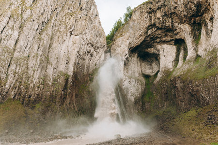 A high, stormy waterfall flowing down the massive rocks of Djily-su. A journey through the mountain...