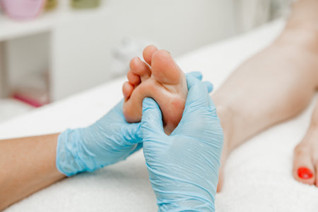 Foot massage in a spa salon, close-up. masseur with gloves massages feetの写真素材