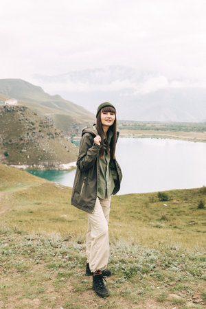 a girl standing on the edge of a mountain and a lake behind her. Caucasusの写真素材