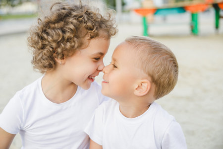 portrait of a boy and a girl, brother and sister. brother and sister looking at each other sweetlyの写真素材