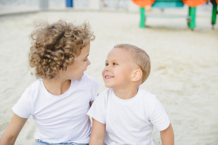 portrait of a boy and a girl, brother and sister. brother and sister looking at each other sweetlyの写真素材
