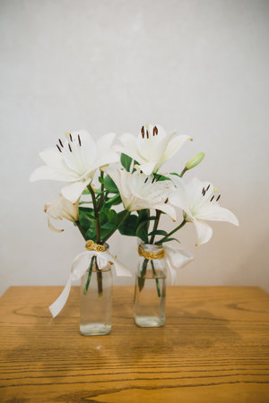 glass vase with lilies on coffee table, close upの写真素材