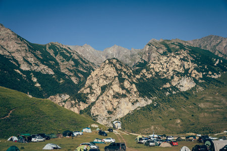 Camping in the mountains with colorful flags and tentsの写真素材