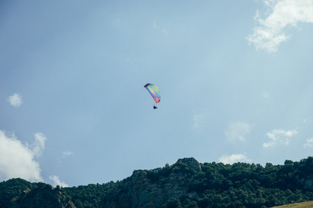 Paragliding against the backdrop of a clear blue sky and mountains.Papraplans in Chegem, Kabardino-Balkariaの写真素材