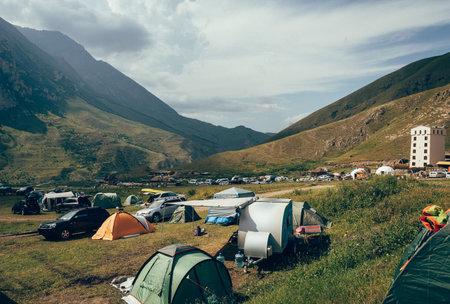 Camping in the mountains with colorful flags and tentsの写真素材