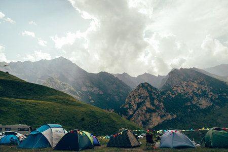 Camping in the mountains with colorful flags and tents