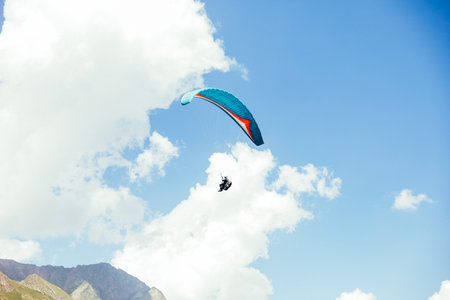 Paragliding against the backdrop of a clear blue sky and mountains.Papraplans in Chegem, Kabardino-Balkariaの写真素材