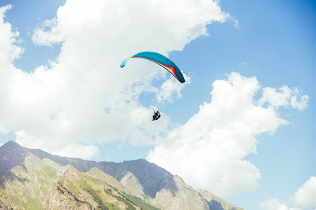 Paragliding against the backdrop of a clear blue sky and mountains.の写真素材