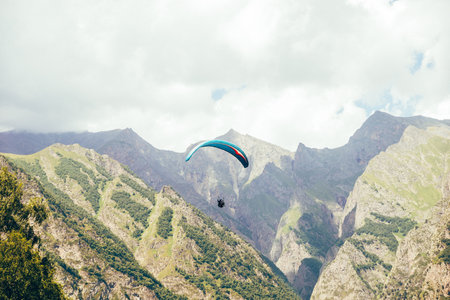 Paragliding against the backdrop of a clear blue sky and mountains.Papraplans in Chegem, Kabardino-Balkariaの写真素材